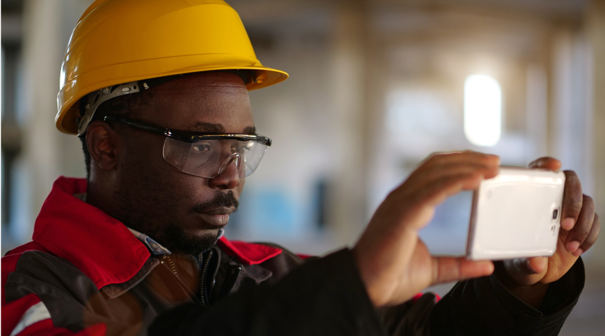 construction worker taking a photograph with a smart phone